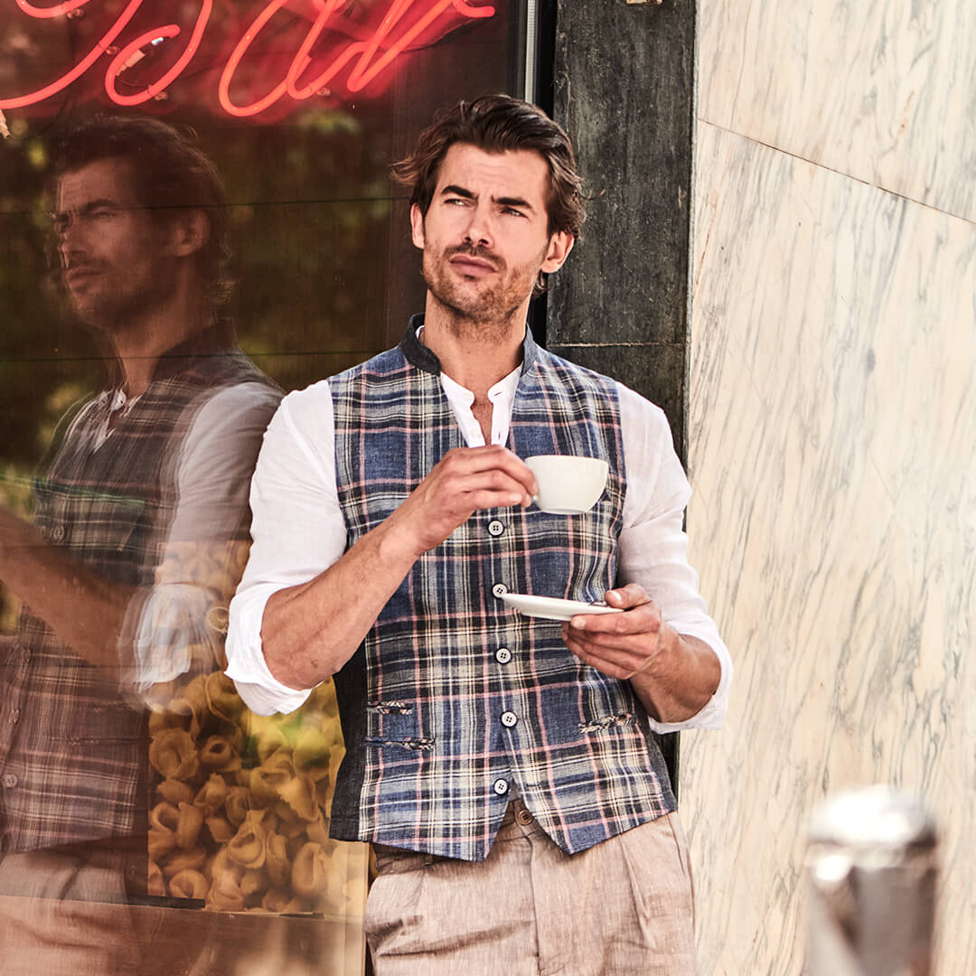 Model trägt DORNSCHILD Herrenweste mit Stehkragen in Nachtblau mit Karomuster im urbanen Sommer-Look