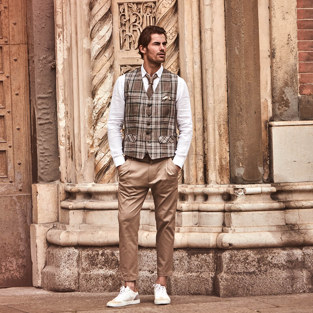 Model trägt DORNSCHILD Leinen Herrenweste in Braun mit klassischem Karomuster im smart-casual Sommer-Look