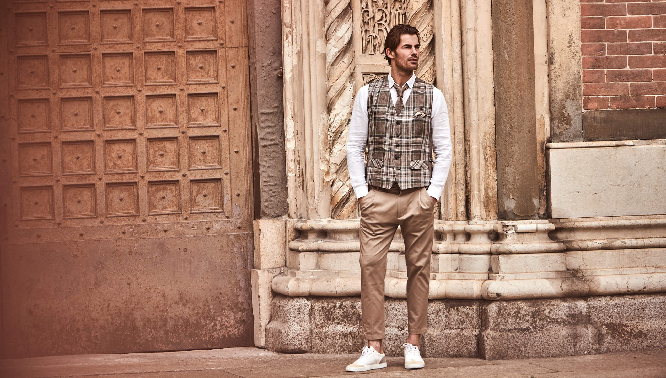 Model trägt DORNSCHILD Leinen Herrenweste in Braun mit klassischem Karomuster im smart-casual Sommer-Look