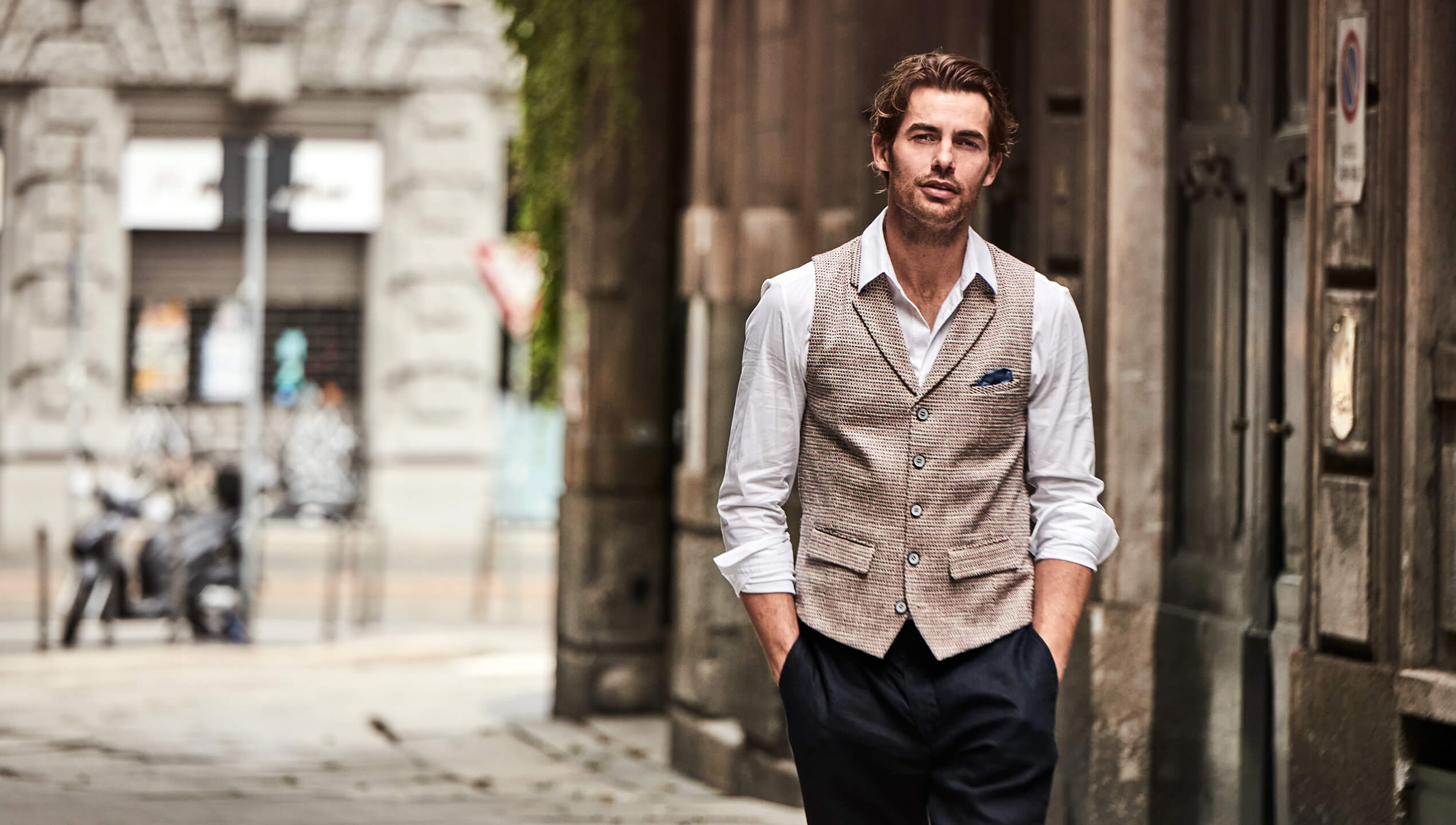 Model trägt DORNSCHILD Herrenweste mit Revers in Naturton mit fein gewebter Struktur im stilvollen Sommer-Look