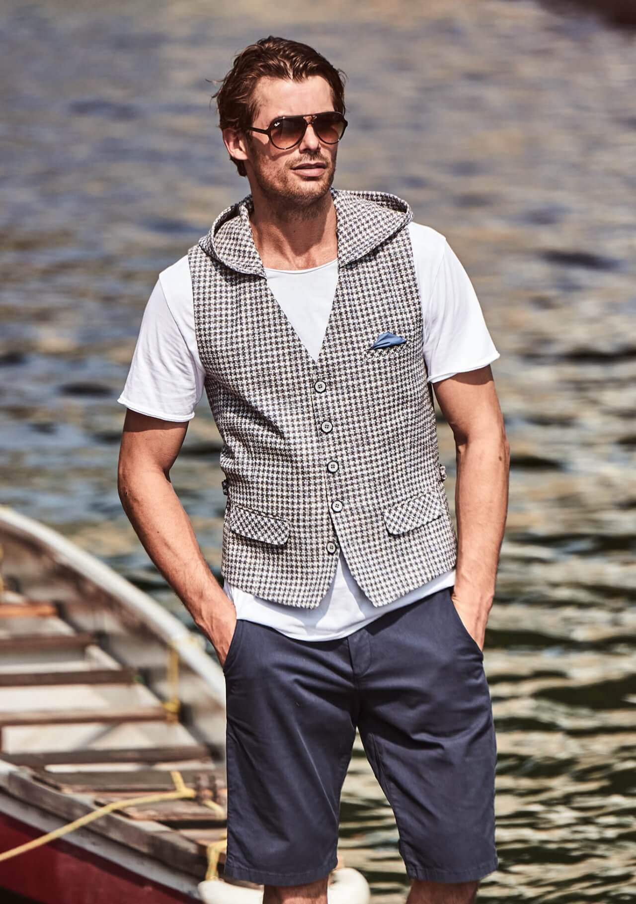 Model trägt DORNSCHILD Herrenweste in Creme mit fein gewebter Struktur und abnehmbarer Kapuze im sportlich-lässigen Sommer-Styling