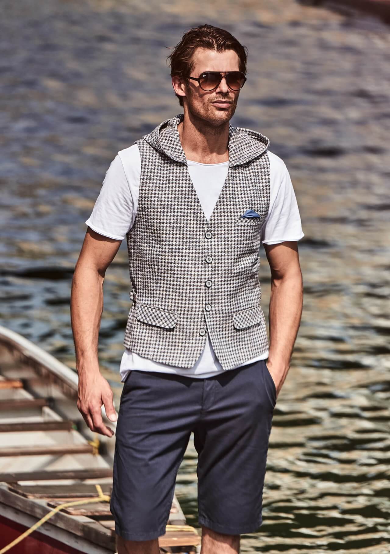 Model trägt DORNSCHILD Herrenweste in Creme mit fein gewebter Struktur und abnehmbarer Kapuze im sportlich-lässigen Sommer-Styling