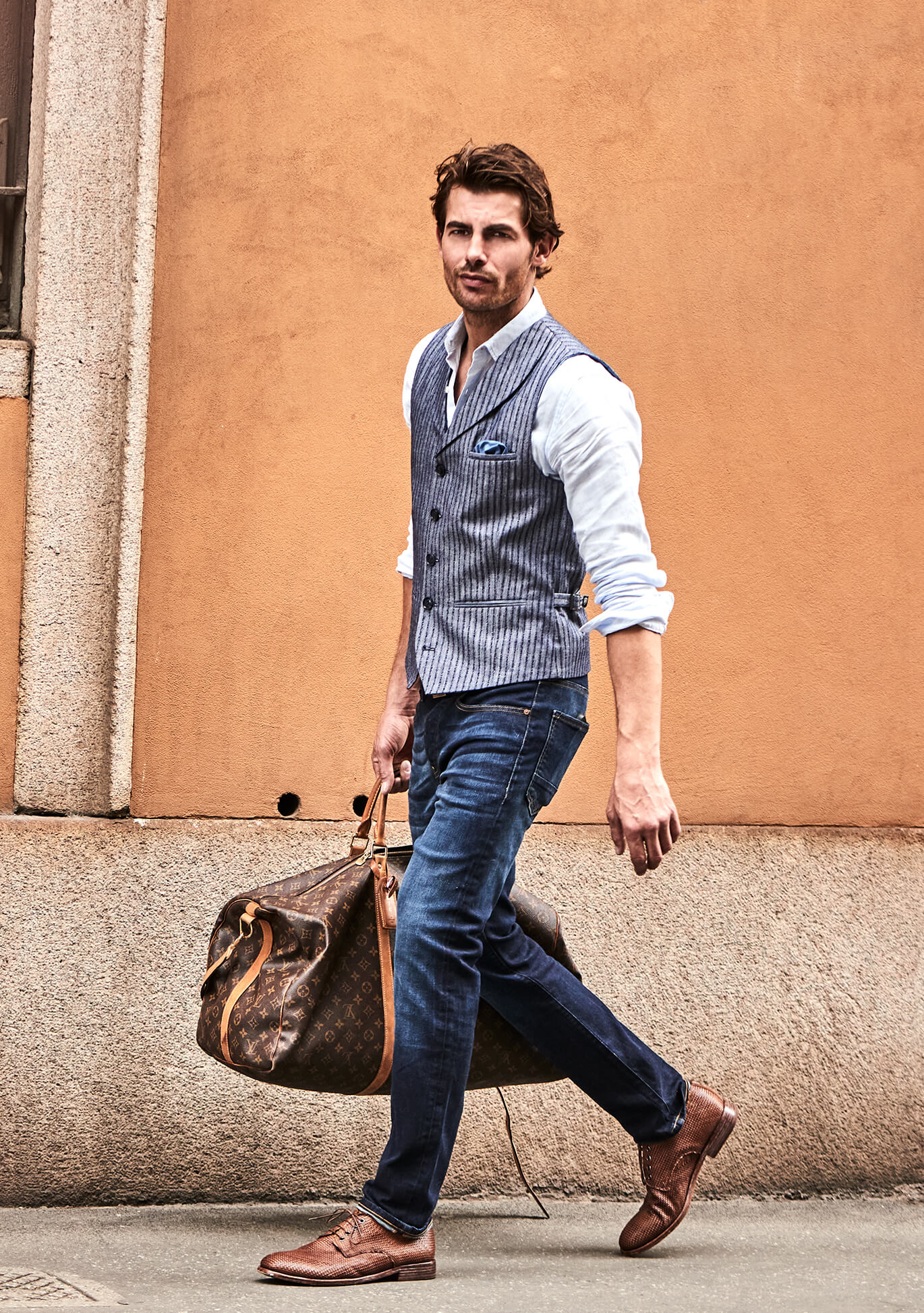 Model trägt DORNSCHILD Herrenweste mit Revers in hellem Denimblau mit feinen dunkelblauen Streifen im lässig-stilvollen Sommer-Look