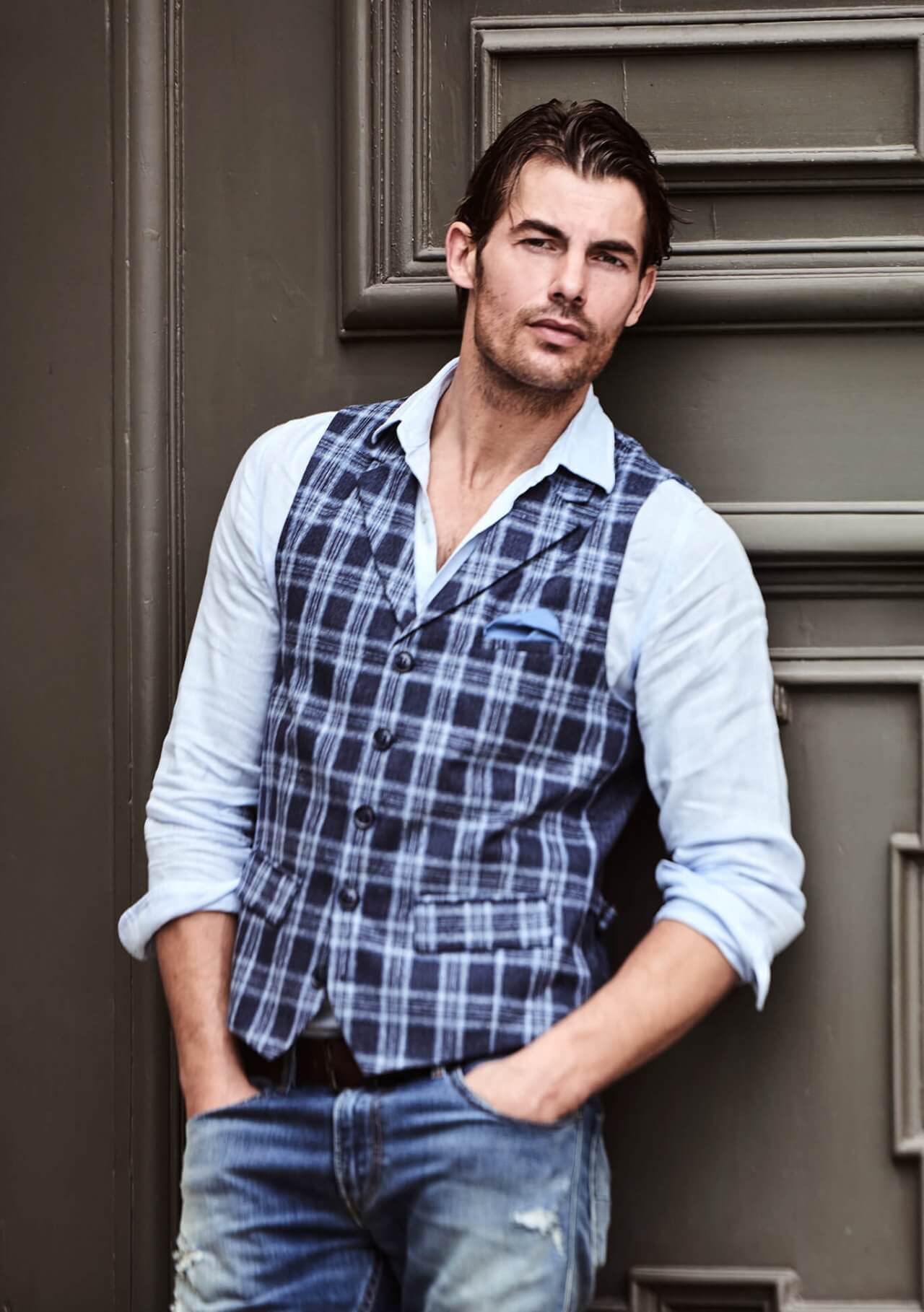 Model trägt DORNSCHILD Herrenweste mit Revers in Nachtblau mit hellblau-silbergrauem Karomuster im smart-casual Sommer-Look