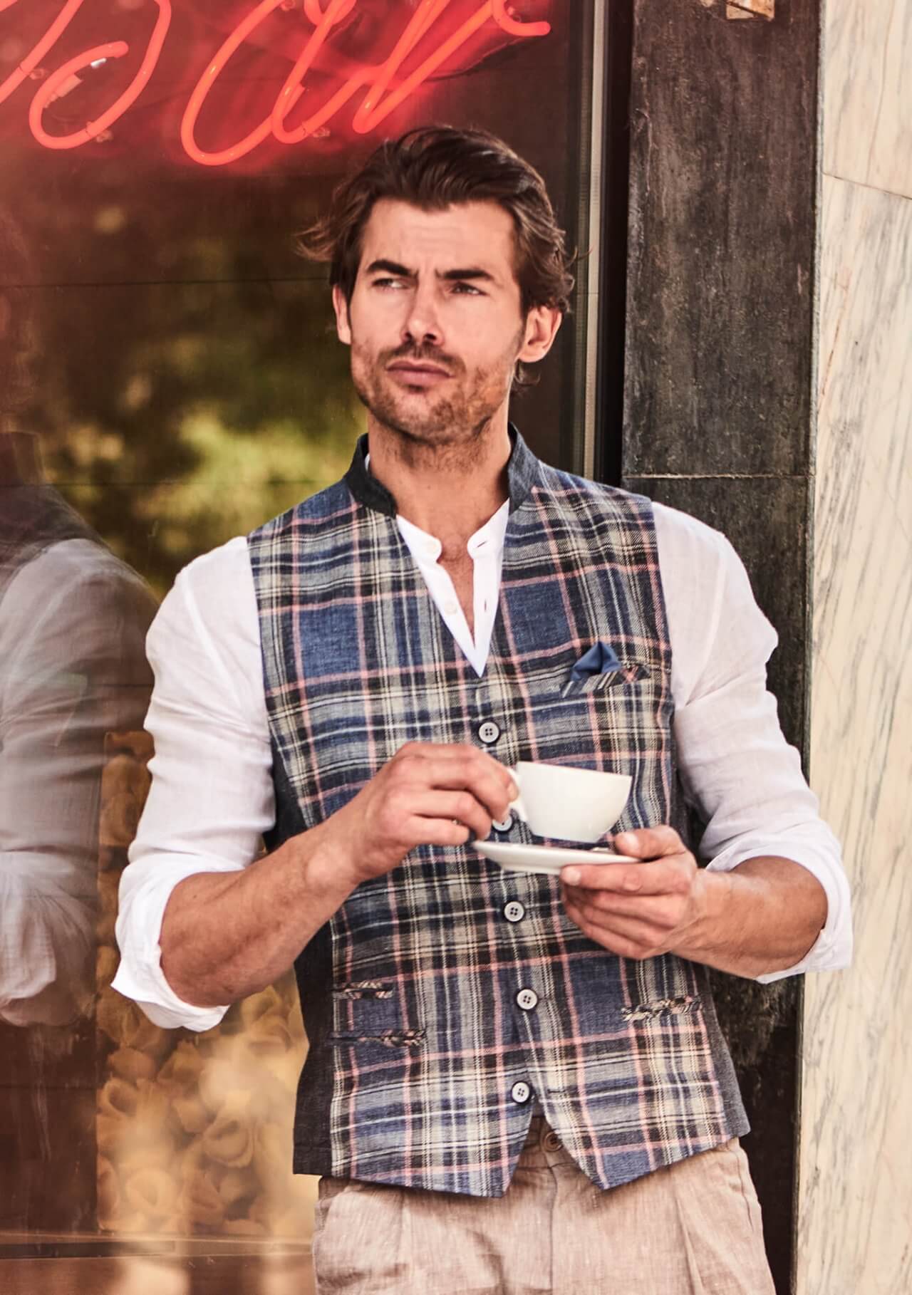 Model trägt DORNSCHILD Herrenweste mit Stehkragen in Nachtblau mit Karomuster im urbanen Sommer-Look