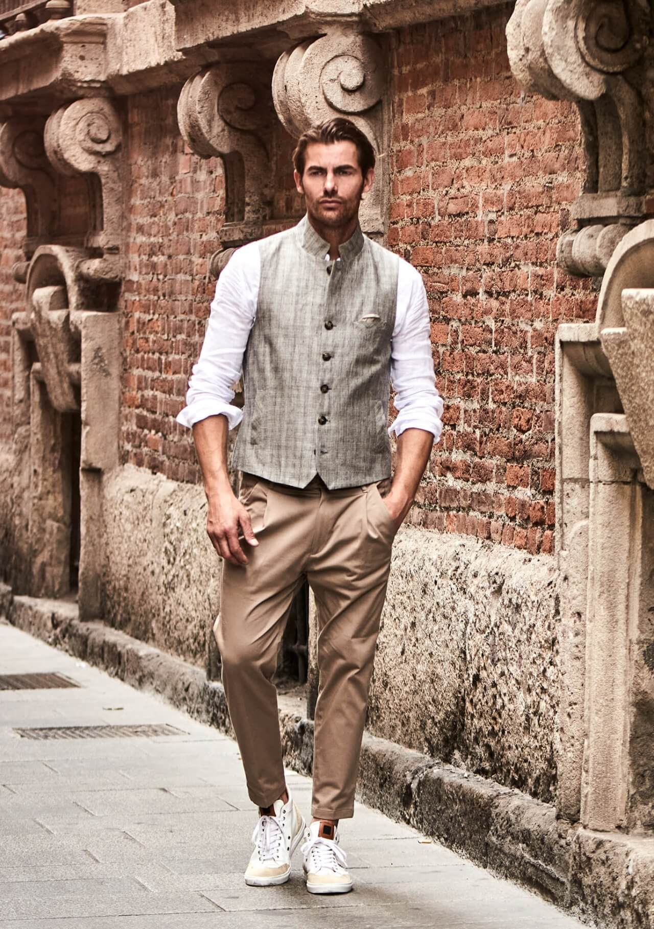 Model trägt DORNSCHILD hochgeschlossene Herrenweste in hellem Taupe mit feinem Streifenmuster im entspannten Sommer-Look