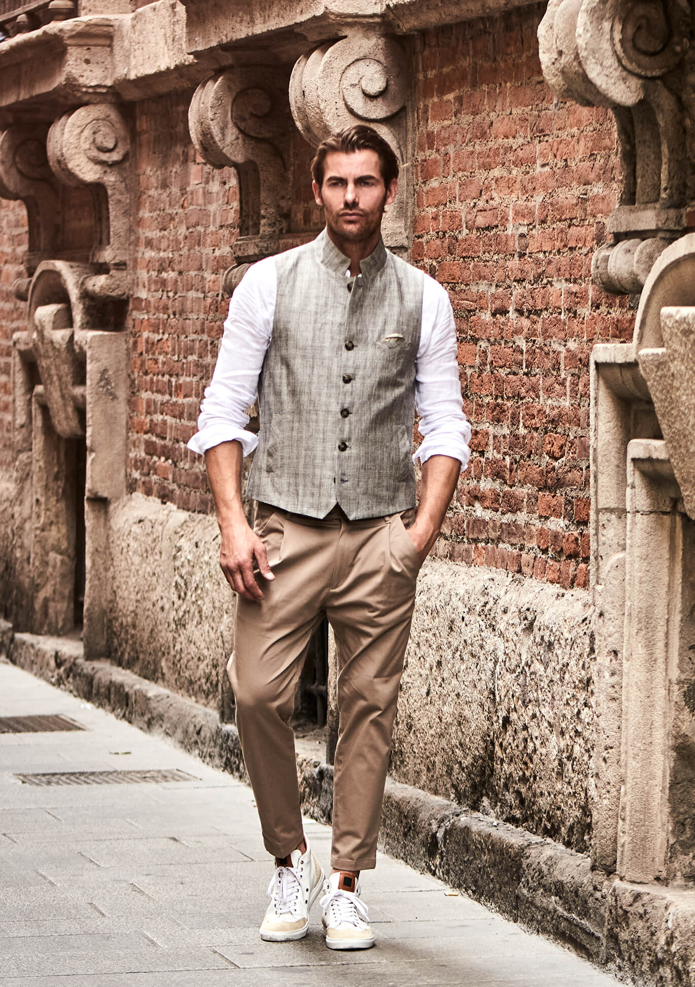 Model trägt DORNSCHILD hochgeschlossene Herrenweste in hellem Taupe mit feinem Streifenmuster im entspannten Sommer-Look