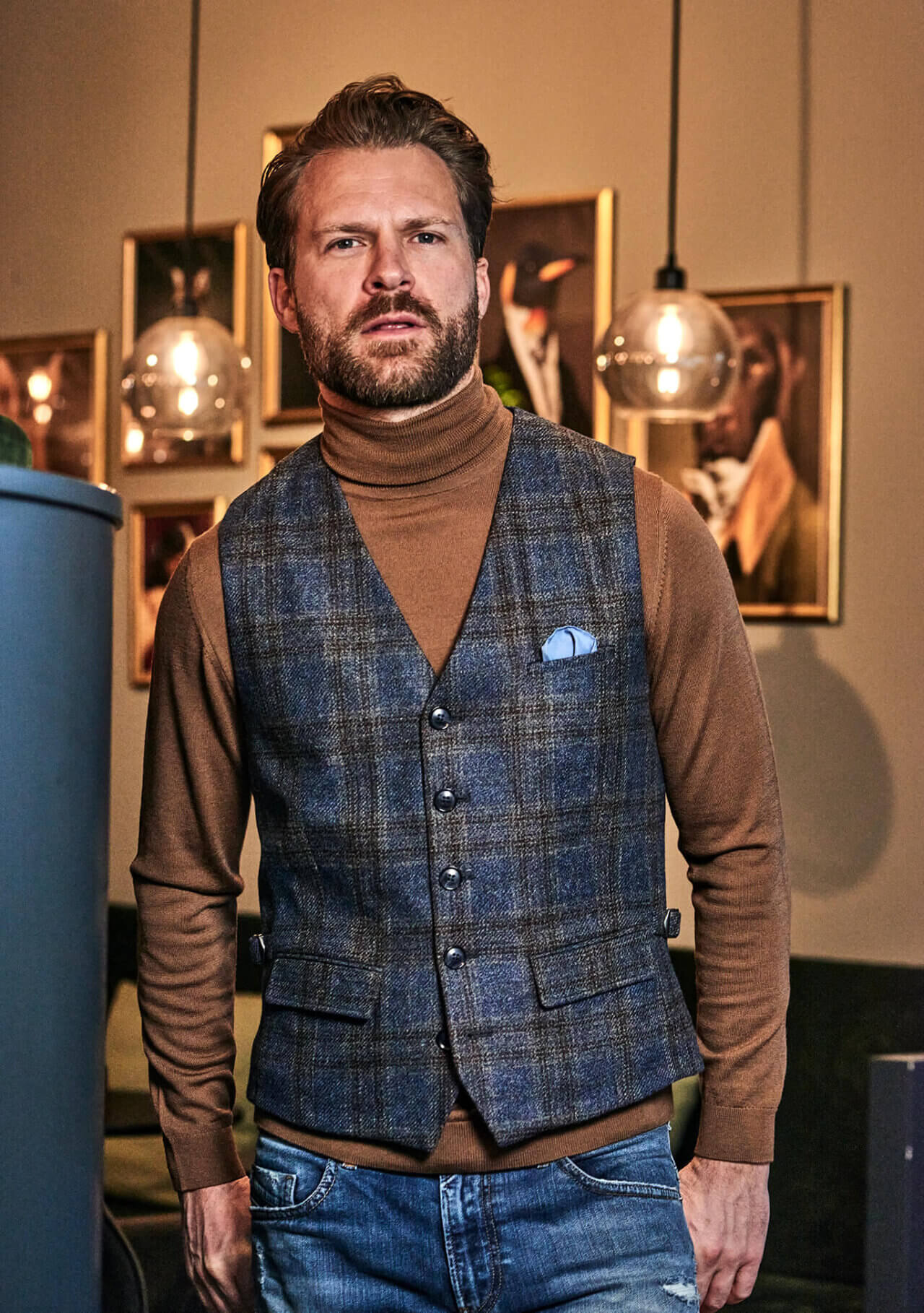DORNSCHILD Herrenweste HW26 W1-4 blau-grau kariert, getragen mit braunem Rollkragen, Denim und blauem Einstecktuch.