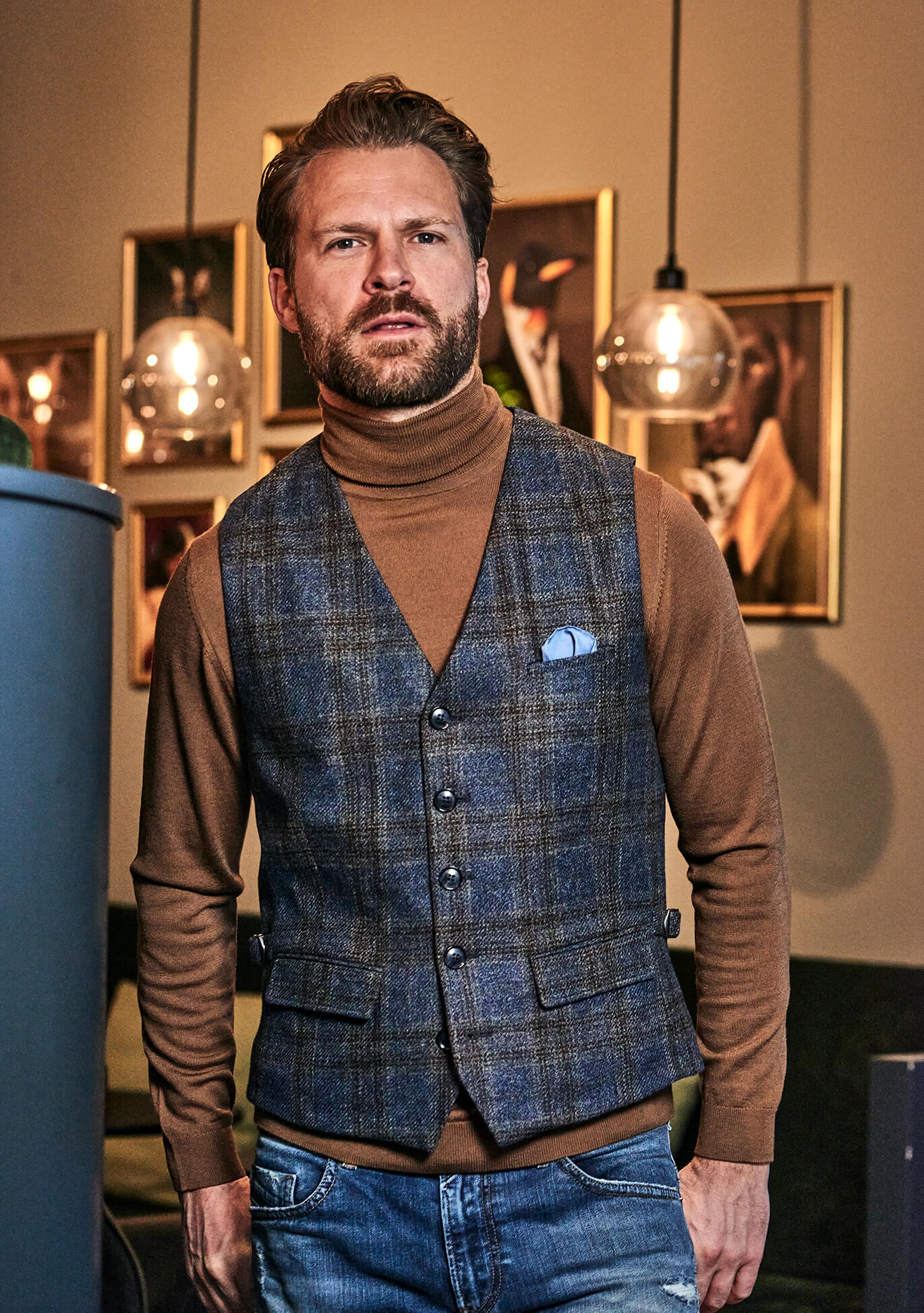 DORNSCHILD Herrenweste HW26 W1-4 blau-grau kariert, getragen mit braunem Rollkragen, Denim und blauem Einstecktuch.